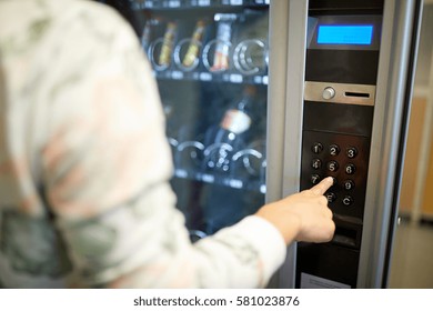 sell, technology and consumption concept - hand pushing button on vending machine operation panel keyboard