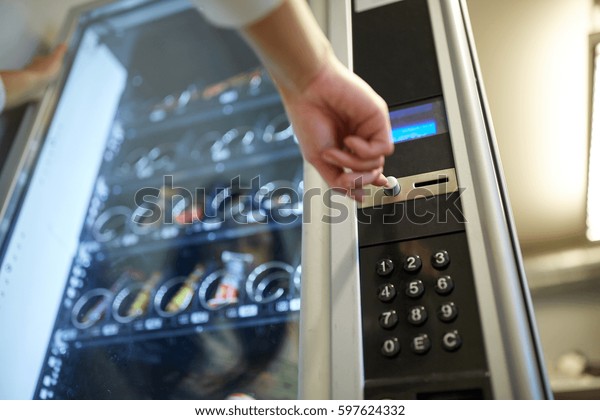 sell, technology and consumption\
concept - hand pushing button on vending machine operation\
panel