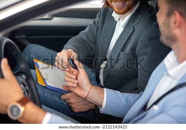 The\
seller hands over the keys of the new car to the customer in a\
pleasant atmosphere at auto shop. Car, shop,\
buying