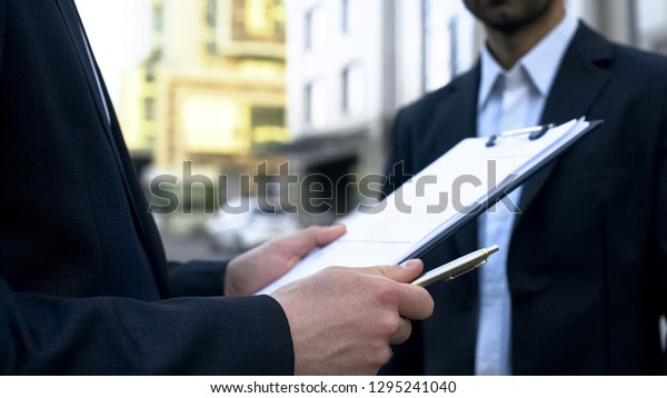 Seller looking through list, searching name of man\
buying auto, business\
deal