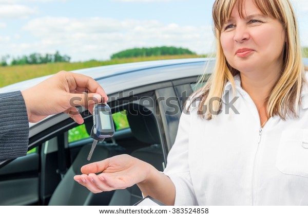 the seller\
presents the woman key from the new\
car