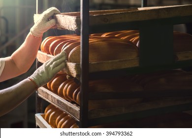 Seller puts  bread on  shelf. Fresh buns from the oven. Baking bread. Transportation of baking. Confectionery. - Powered by Shutterstock