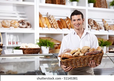 The seller in shop holds a basket with rolls - Powered by Shutterstock