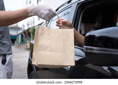 Seller Wearing Glove Bringing Shopping Brown Paper Bag To Woman Driver Car Open Window Driving Thru Pickup Food. Social Distancing Requirements Home Delivery Concept