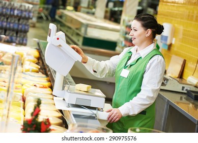 seller woman assistant in supermarket working with scales balance weghing cheese at shop - Powered by Shutterstock