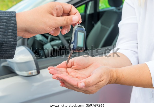 Seller\'s hand with car\
keys and hands buyer