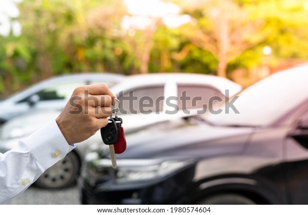 selling\
car, car sale, deal concept The dealer gives the car keys to the\
new owner or renter with an insurance\
contract.
