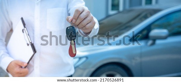 selling car, car sale, deal concept The dealer\
gives the car keys to the new owner or renter with an insurance\
contract. banner
