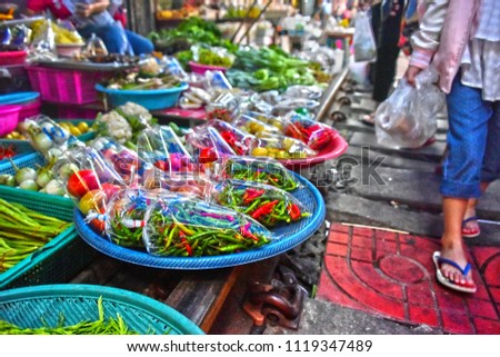 Selling food on the Maeklong Railway market in Thailand.