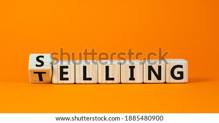 Selling or telling symbol. Turned wooden cubes and changed the word 'telling' to 'selling'. Beautiful orange background, copy space. Business and storytelling selling or telling concept.