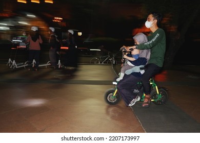 Semarang, Centre Java Indonesia, March 23, 2022 :  Night Holiday, A Small Family Is Driving A Recreational Vehicle (mini Motorbike)