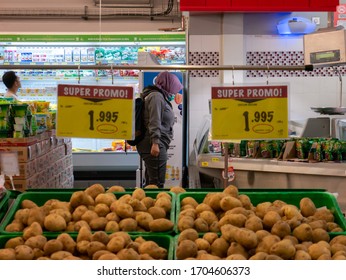 Semarang, Indonesia - April 15 2020: A Hijab Woman Using A Complete Medical Personal Protective Equipment Choosing Food In A Supermarket Under The Covid-19 Pandemic Conditions.