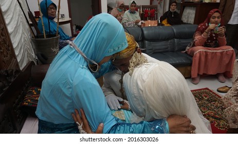 SEMARANG, INDONESIA – FEBRUARY 15, 2021 : A Child Is Apologizing To His Parents While Crying Because He Has To Be Separated From His Parents After Getting Married And Forming A New Family