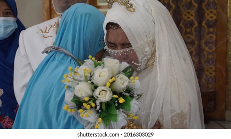 SEMARANG, INDONESIA – FEBRUARY 15, 2021 : A Child Is Apologizing To His Parents While Crying Because He Has To Be Separated From His Parents After Getting Married And Forming A New Family