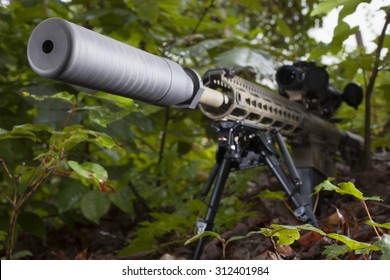 Semi Automatic Rifle With A Suppressor In The Trees