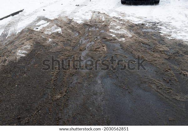 Semi\
melted snow mud at asphalt parking lot road\
winter