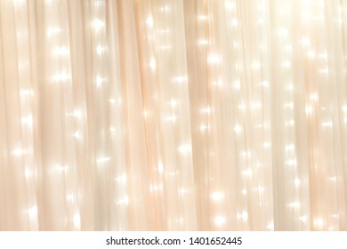 Semi Opaque See Through Beige Curtain In Front Of Strings Of Starry Blinking Lights