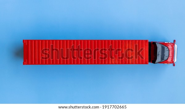 Semi\
trailer truck lorry container cargo vehicle on blue background,\
View from above, Aerial top view of semi truck with container\
cargo, Business logistic and transportation\
compay.
