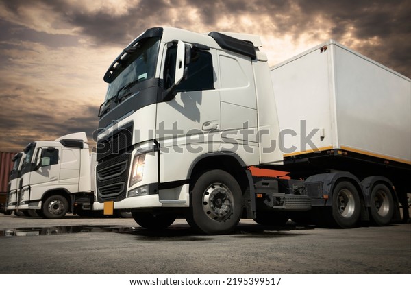 Semi TrailerTrucks\
Parked Lot at The Sunset Sky. Shipping Container. Delivery,\
Transit. Engine Diesel Truck Tractor. Industry Freight Trucks\
Logistics Cargo\
Transport.	