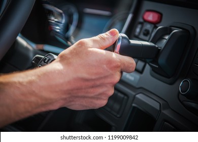 Semi Truck Air Brake Releasing By Caucasian Driver. Vehicle Interior Closeup Photo.