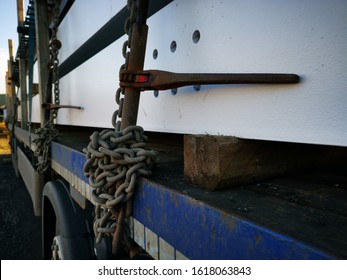 Semi Truck, Flatbed Trailer Carrying White Painted Fabricated Steel Girders Ready To Be Constructed On Site Secured By Chains And Warwick Ratchets.