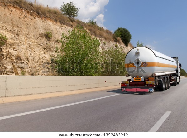 Semi truck\
with oil cistern on asphalt road\
highway