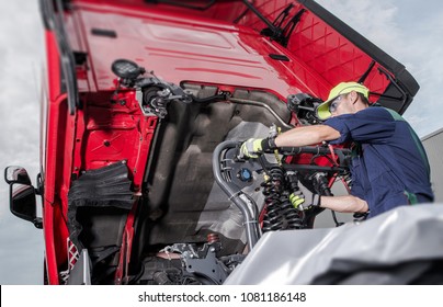 Semi Truck Under Maintenance. Caucasian Truck Mechanic Working To Fix The Tractor.