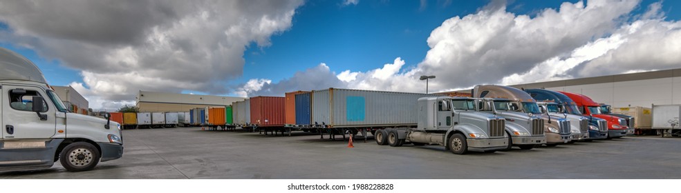 Semi Trucks Lined Up On A Parking Lot At Logistics Warehouse