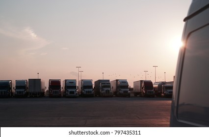 Semi Trucks Lined Up At A Truck Stop With Birds In The Sky.