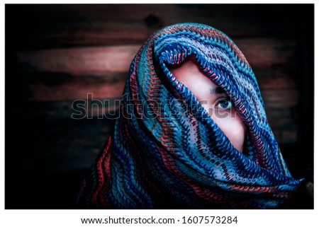 
semi-covered woman's face with colorful cloak