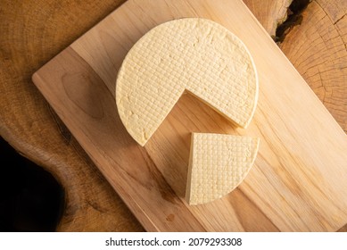 Semi-cured cheese from Brazil, beautiful Brazilian cheese arranged on light rustic wood, selective focus. - Shutterstock ID 2079293308