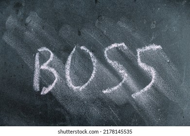 Semi-erased Word BOSS On Black Chalkboard. Handwritten Word. Fuzzy Letters On Black Surface.