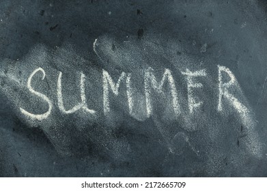 Semi-erased Word SUMMER On Black Chalkboard. Handwritten Word. Fuzzy Letters On Black Surface. The Concept Of The Changing Seasons Of The Year.