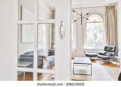 Semi-open door leading to a cozy living room - Shutterstock ID 2086150432