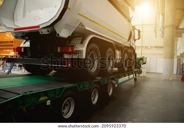 Semi-trailer transports a lorry.\
Transporting a heavy truck by\
semitrailer.