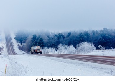 Semi-trailer truck headed for fog in the winter.