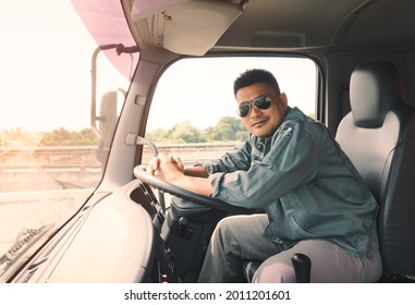 Semi-truck Driver Wearing Sunglasses Happy Smiling In The Cockpit. 
Mature Young Man Asian Transport Business Owner Smile Confident Proud. Male Delivery Driving Car Goods Services Customers.