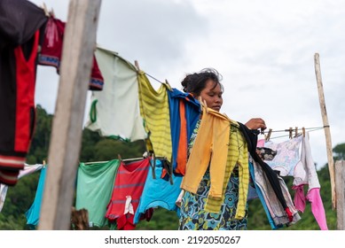 Semporna, Malaysia - August 28, 2022: Unidentified Woman Picking  Up The Clothes On The Clothesline.