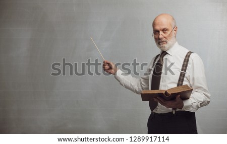 Senior academic professor giving a lecture and pointing at the empty blackboard using a stick: knowledge and traditional education concept Foto stock © 