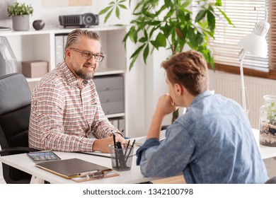 Senior Account Manager And Young Man During Job Interview In Small Firm