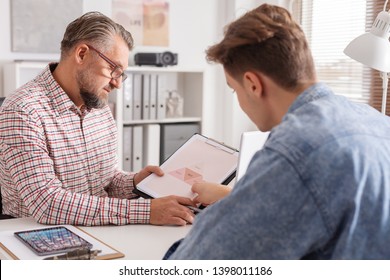 Senior Account Manager And Young Man During Job Interview In Small Firm