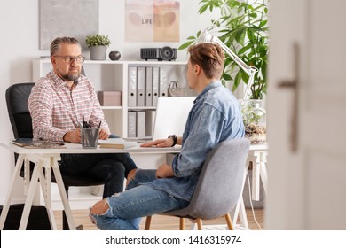 Senior Account Manager And Young Man During Job Interview In Small Firm