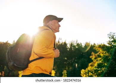 Senior Active Tourist Man With Black Backpack Make Fitness By Hiking Exercise In Mountain Side View