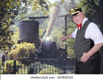 A senior adult conductor point to a coming train while looking at the viewer.