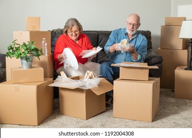 Senior Adult Couple Packing or Unpacking Moving Boxes. - Powered by Shutterstock