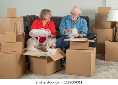 Senior Adult Couple Packing Or Unpacking Moving Boxes.