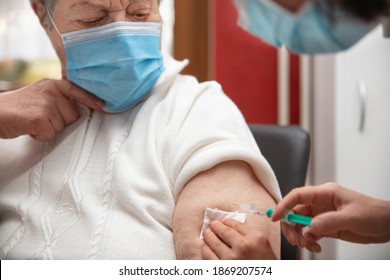 Senior Adult Elderly Woman With Grey Hair Is Receiving A Vaccination Against Covid, Concept Pandemic Coronavirus Protection Or Flu