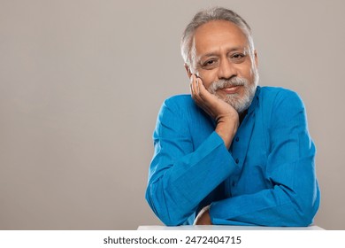 A SENIOR ADULT MAN SITTING RELAXED AND LOOKING AT CAMERA - Powered by Shutterstock