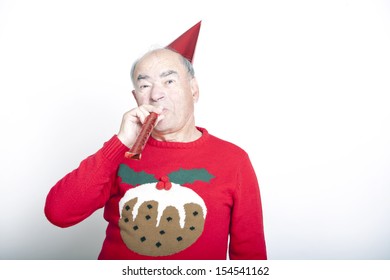 Senior Adult Man Wearing Christmas Jumper Blowing Party Blower