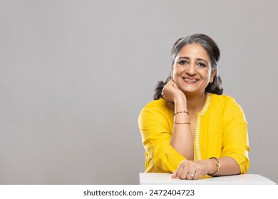 A SENIOR ADULT WOMAN SITTING AND SMILING AT CAMERA - Powered by Shutterstock